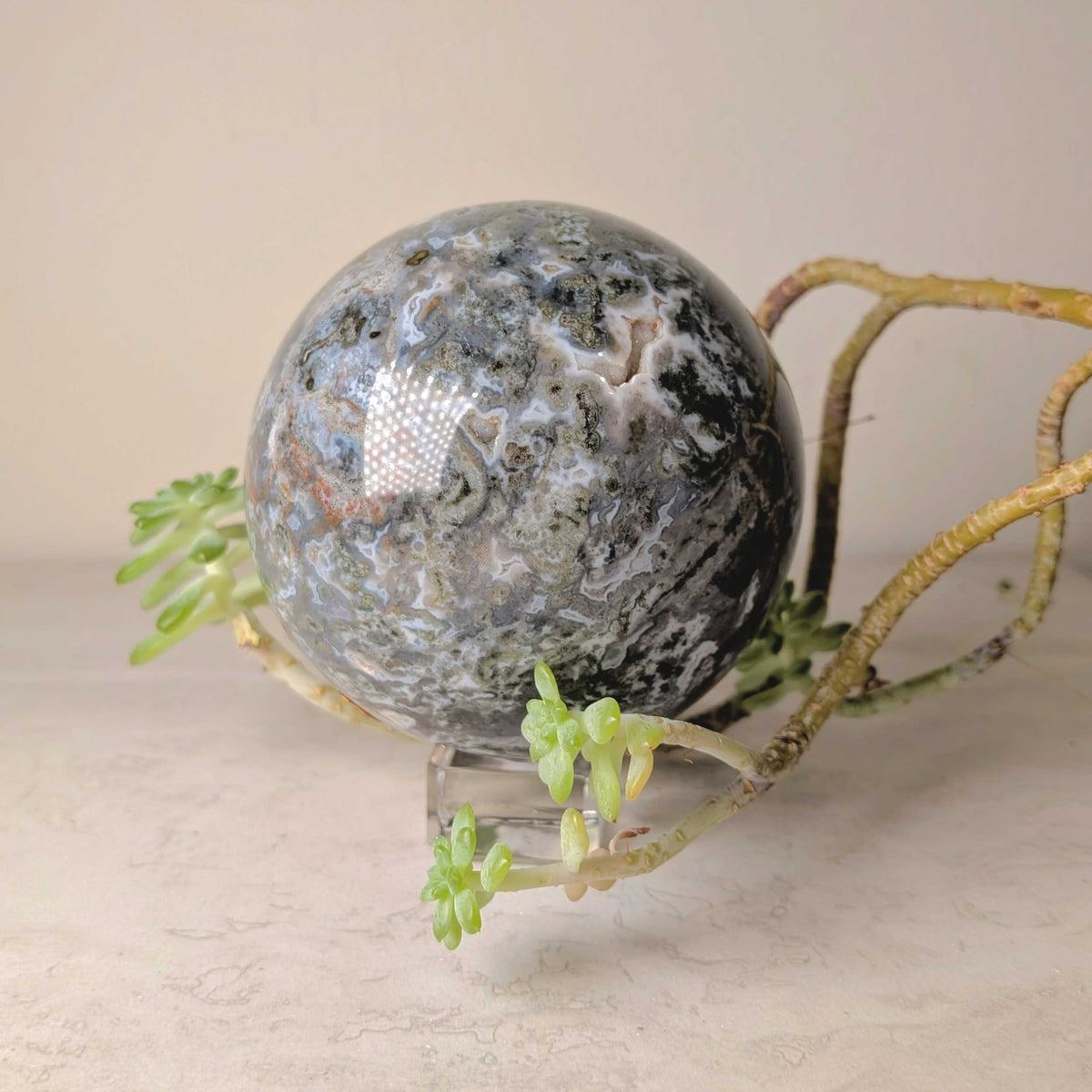 Indigo gabbro crystal sphere, polished stone with mixed black, gray and indigo tones, at Ordinary Magic in Savannah, GA.