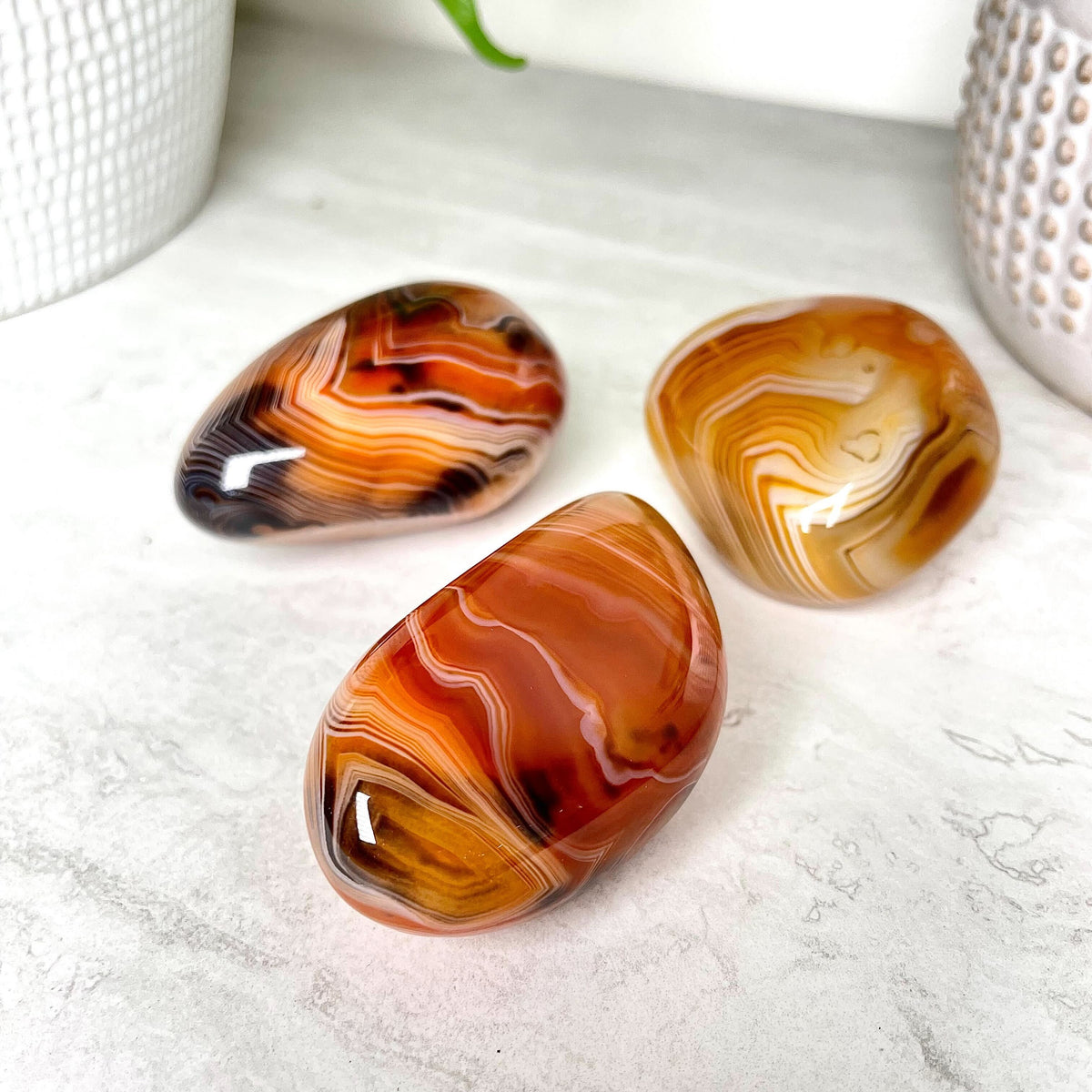 Banded sardonyx palm stone in reddish-brown and cream layers, at Ordinary Magic in Savannah, GA.