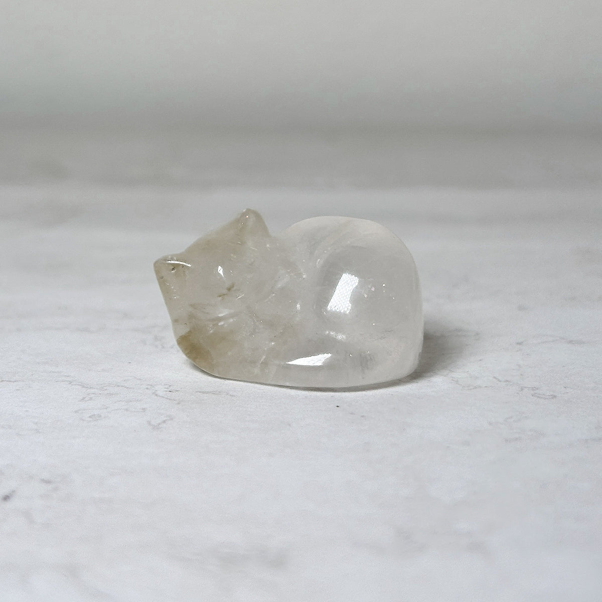 Polished clear quartz, 1", sleeping cat crystal carving, view 9, at Ordinary Magic in Savannah, GA.