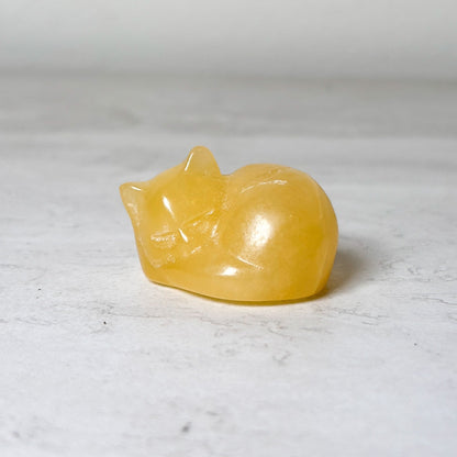Polished yellow calcite sleeping cat crystal carving, view 8, at Ordinary Magic in Savannah, GA.