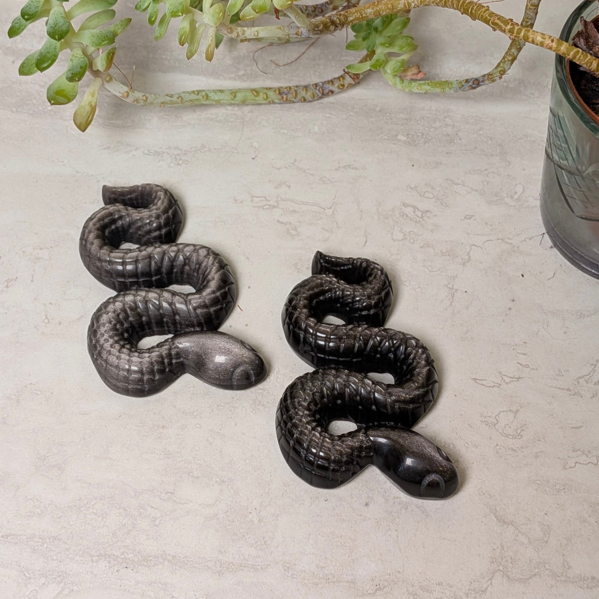 Sheen obsidian snake carving showing the natural flash in the polished stone, at Ordinary Magic in Savannah, GA.