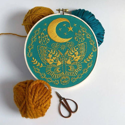 Lunar Moth Embroidery Kit by Rikrack, a celestial moth with crescent moon, stars and botanicals stitched in an embroidery hoop, at Ordinary Magic in Savannah, GA.