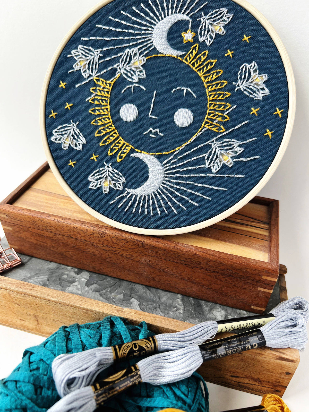 Moonglow Embroidery Kit by Rikrack, fireflies around a glowing moon and setting sun stitched in an embroidery hoop, at Ordinary Magic in Savannah, GA.