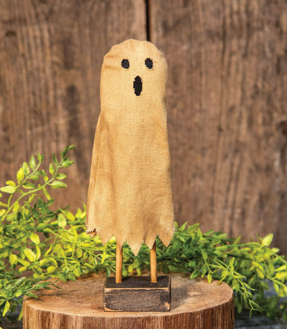 Primitive folk-art ghost figure on a wooden base, at Ordinary Magic in Savannah, GA.