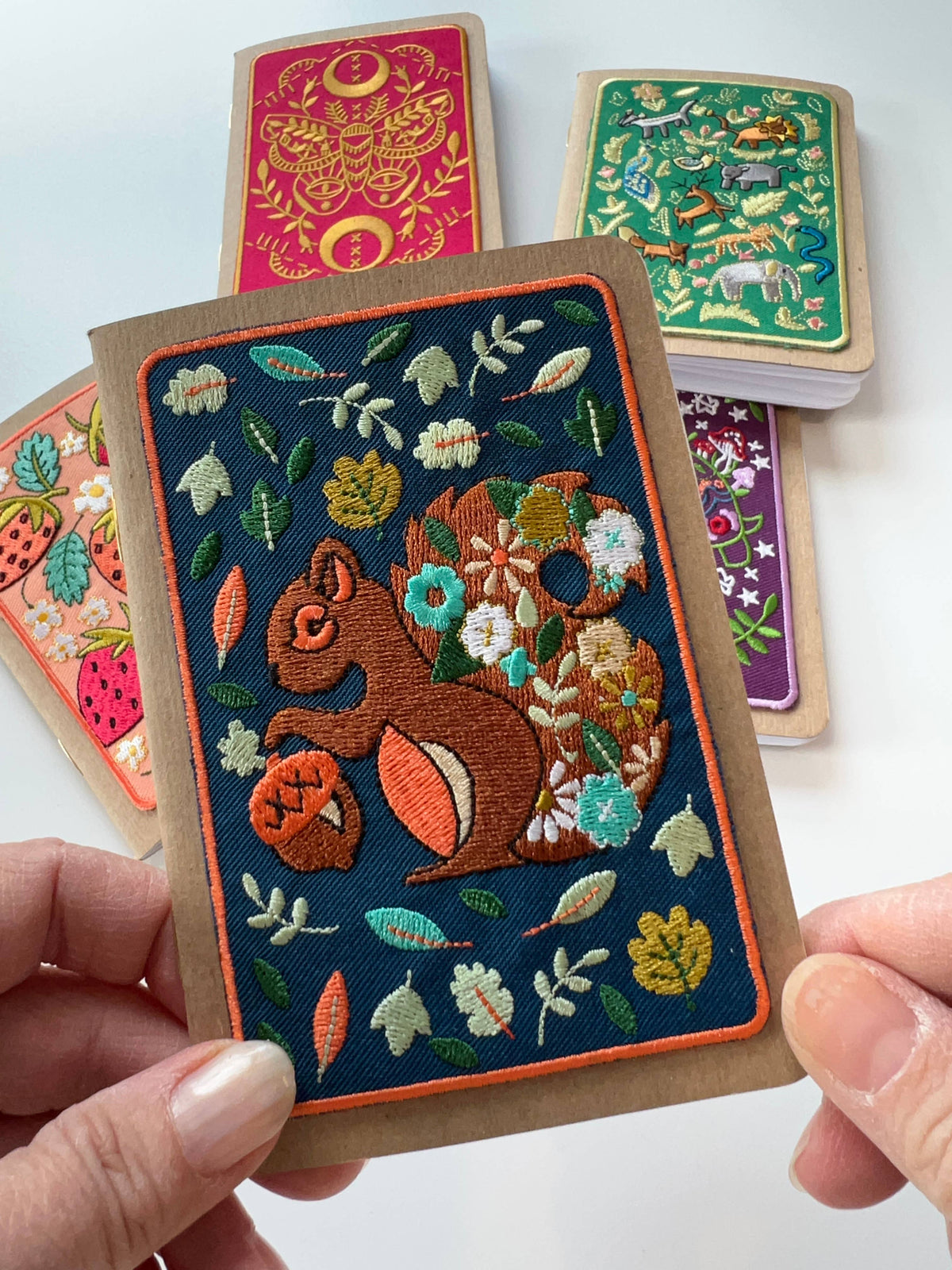 Squirrel embroidery pocket notebook, embroidered squirrel with leaves and flowers on a kraft paper cover.