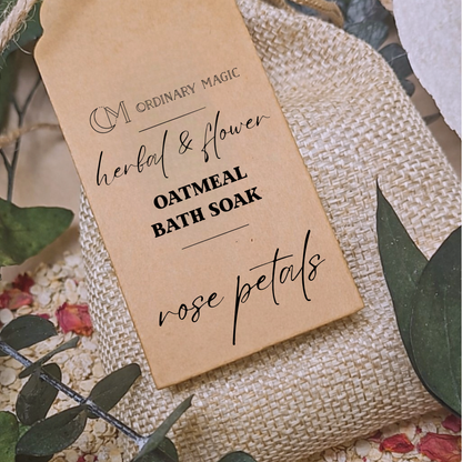 Kraft paper tag for 'Oatmeal Bath Soak with Rose Petals' by Ordinary Magic on a textured surface with green leaves and flowers.