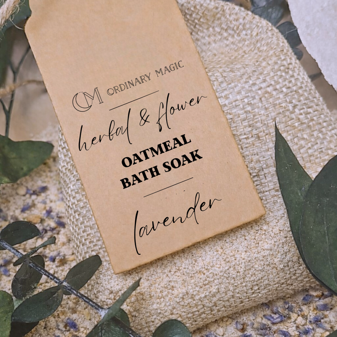 Bath soak packaging with 'Ordinary Magic' branding on a textured surface with green leaves and lavender flowers.