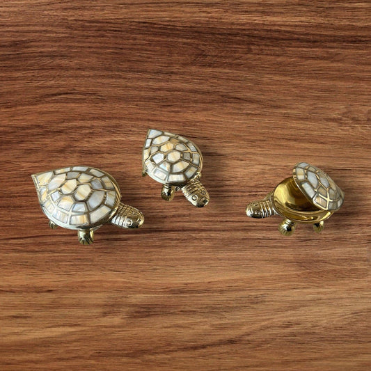 Three decorative turtle figurines on a wooden surface