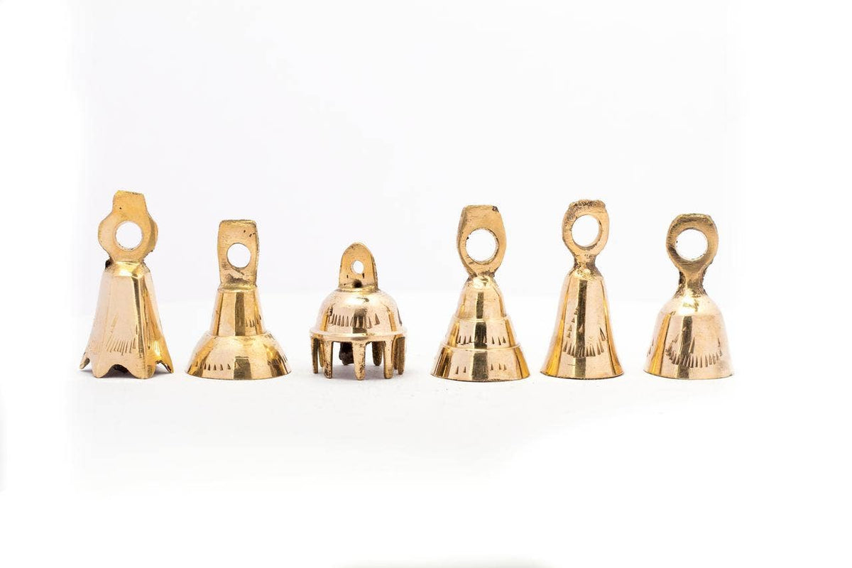 Handcrafted brass bells in assorted artisan designs with a warm brass finish, at Ordinary Magic in Savannah, GA.