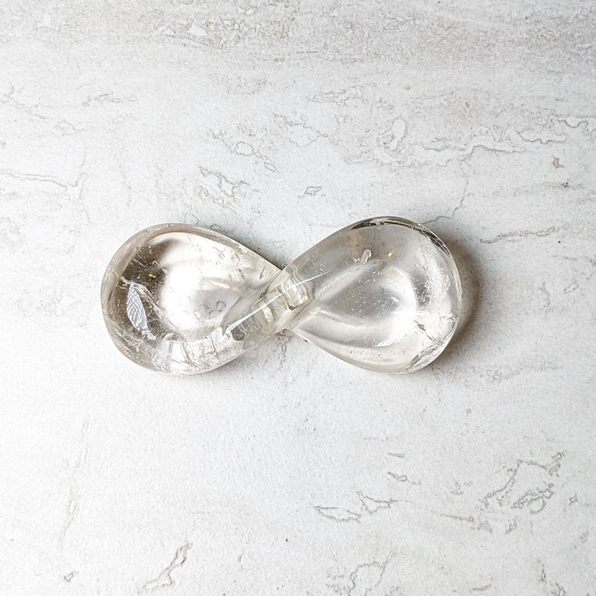 Clear quartz carved infinity symbol, polished and translucent