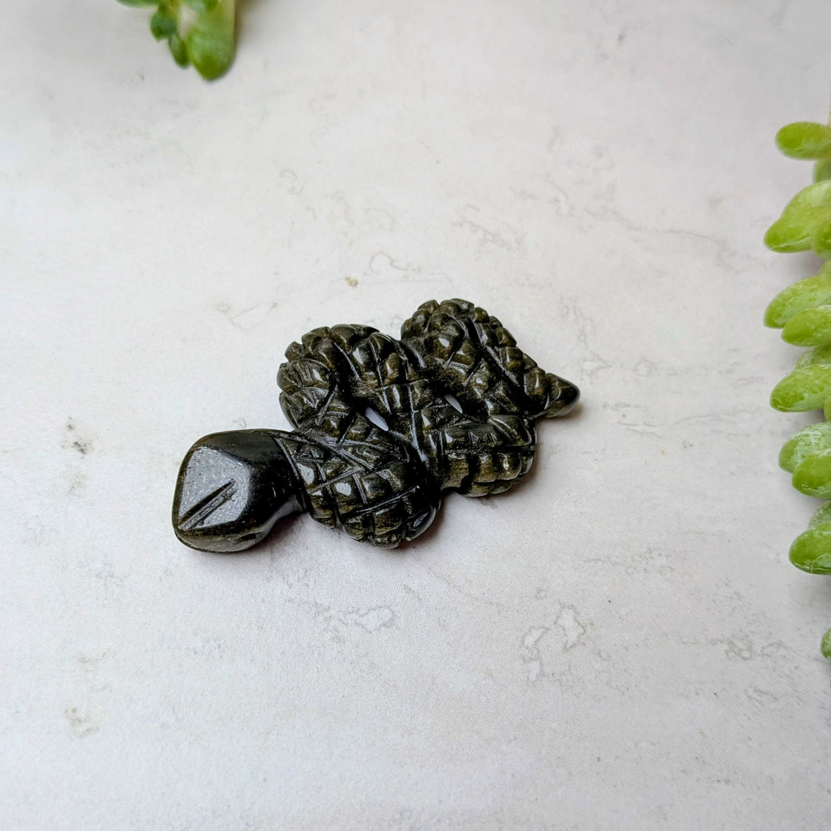 Carved crystal snake figure in gold sheen obsidian, at Ordinary Magic in Savannah, GA.