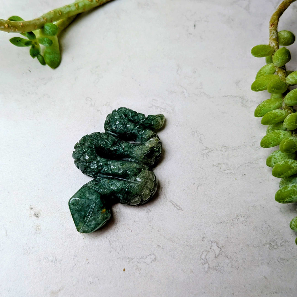 Carved crystal snake figure in green aventurine, at Ordinary Magic in Savannah, GA.