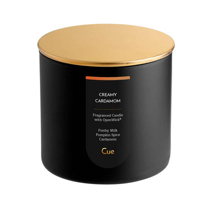 Cue Creamy Cardamom candle in a black jar with a gold lid — milk, coffee, and spiced caramel, at Ordinary Magic in Savannah, GA.