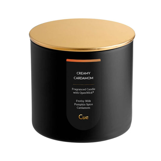 Cue Creamy Cardamom candle in a black jar with a gold lid — milk, coffee, and spiced caramel, at Ordinary Magic in Savannah, GA.