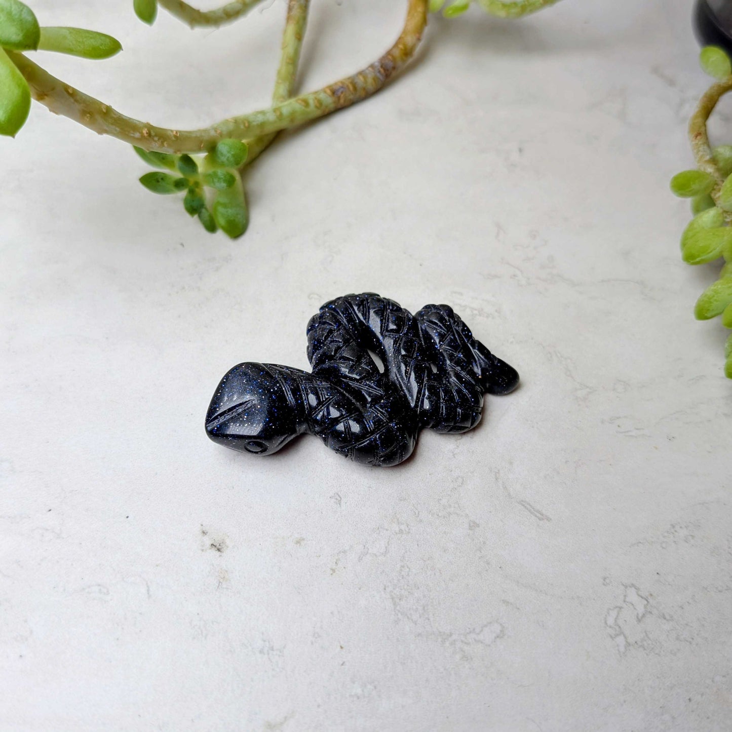 Carved crystal snake figure in blue goldstone, at Ordinary Magic in Savannah, GA.