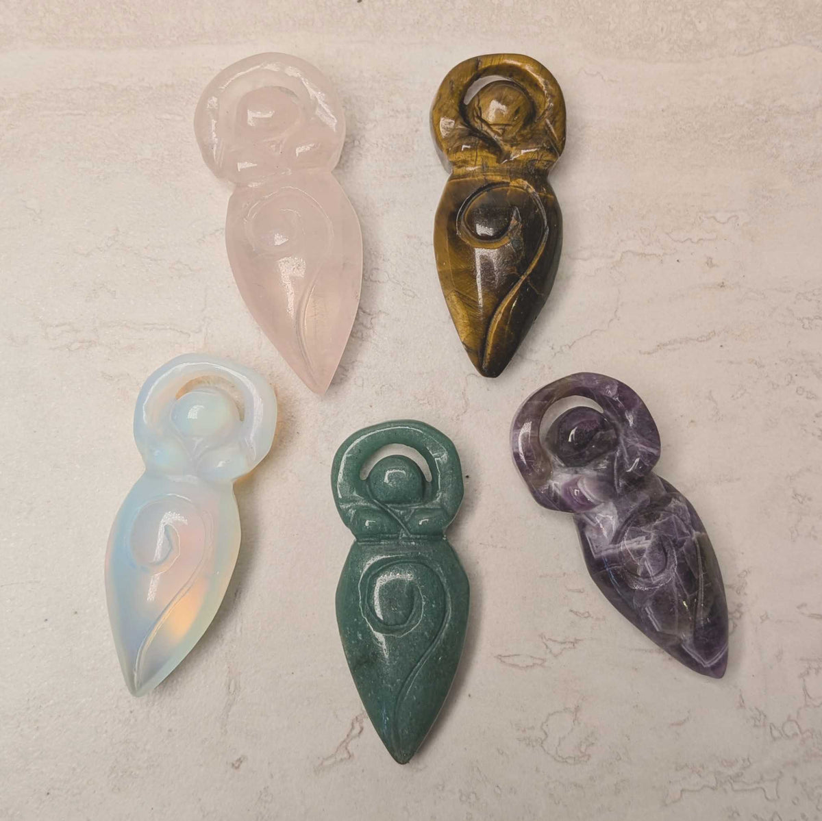 Carved crystal spiral goddess figure with raised arms and a spiral body, at Ordinary Magic in Savannah, GA.