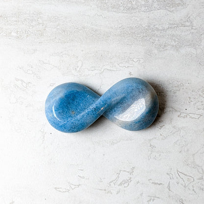 Trolleite carved infinity symbol, polished blue stone