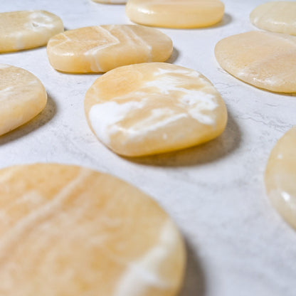 Round beige stones with white veins on a light yellow background